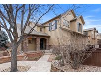 Charming two-story home featuring a stone-accented entryway and professionally landscaped front yard at 10650 Ashfield St, Highlands Ranch, CO 80126