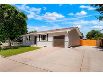Charming single-story home with a well-manicured lawn, a driveway, and an attached single car garage at 5554 Crystal Way, Denver, CO 80239