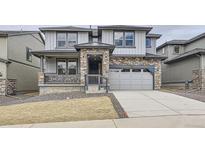 Charming two-story home featuring stone accents, a covered porch, and an attached two-car garage at 15153 W Dequesne Ave, Morrison, CO 80465