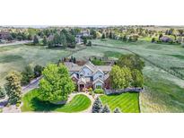 Expansive estate on lush green property featuring mature trees, manicured lawns, and a beautifully designed multi-story home at 7818 S Zeno St, Centennial, CO 80016