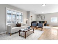 Bright living room with large window and stylish furnishings, with light wood flooring and comfortable seating at 10675 Logan Ct, Northglenn, CO 80233