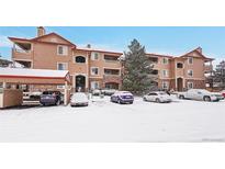 Snow-covered condo building with parking at 8457 S Hoyt Way # 206, Littleton, CO 80128