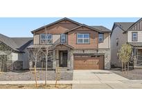 Charming two-story home with stone accents, a two-car garage, and landscaped front yard at 2154 S Gold Bug Way, Aurora, CO 80018