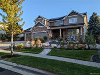 Beautiful two-story home with manicured front yard, stone accents, and a welcoming front porch at 7765 Yankee Ct, Arvada, CO 80007