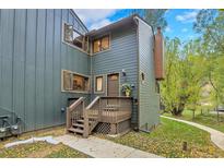 Charming multi-level home featuring a welcoming porch, with green siding, and well-maintained landscaping at 4863 Silver Spruce Ln, Evergreen, CO 80439