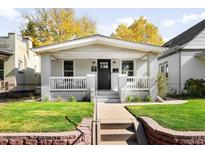 Charming home featuring a well-manicured front yard, covered porch, and classic architectural details at 3884 Osceola St, Denver, CO 80212