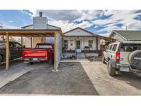 Charming single-story home featuring a front porch and covered parking, all under a beautiful cloudy sky at 655 S Perry St, Denver, CO 80219