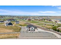 Expansive aerial view of a two-story home on acreage with mountain views and white vinyl fencing at 16197 Paris Way, Brighton, CO 80602