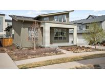 Modern home exterior with a covered porch and well-maintained yard, showcasing its contemporary design at 5050 Akron St, Denver, CO 80238