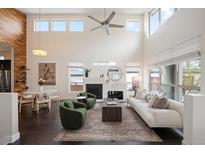 Bright living room featuring soaring ceilings, modern fireplace, and stylish furnishings at 5050 Akron St, Denver, CO 80238