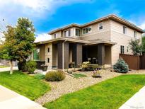 Beautiful two-story home with manicured lawn and appealing brick column porch in a sunny neighborhood at 15468 W 50Th Pl, Golden, CO 80403