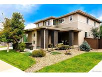 Inviting two-story home featuring well-maintained landscaping and a charming covered front porch with brick pillars at 15468 W 50Th Pl, Golden, CO 80403