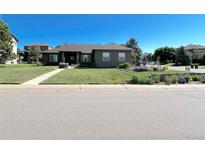 Charming single-story home with a well-manicured lawn, mature trees, and inviting curb appeal at 7170 Windwood Way, Parker, CO 80134