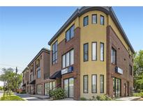 Modern building showcasing a brick and stucco facade with large windows and commercial space at 2700 E Louisiana Ave # 203, Denver, CO 80210