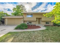 Charming home featuring a two-car garage, well-maintained lawn, and an inviting entrance at 12883 E Nevada Cir, Aurora, CO 80012