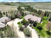 Aerial view of a luxurious house with a large yard and circular driveway at 10010 Steeplechase Dr, Franktown, CO 80116