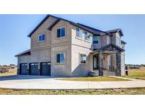 Beautiful shot of a grey stucco two-story house with a large driveway and a stone entryway at 19887 Kershaw Ct, Monument, CO 80132