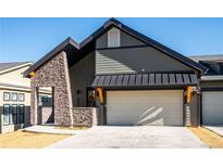 Striking home exterior featuring stone accents, a dark roof, and a two-car garage at 3909 Piney Grove St, Evergreen, CO 80439