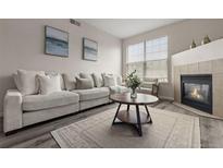 Bright living room featuring a fireplace and large window to provide lots of natural light at 7440 S Blackhawk St # 2-108, Englewood, CO 80112