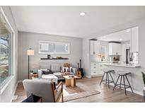 Bright living room featuring modern furniture and hardwood floors seamlessly flowing into an open-concept kitchen at 1601 S Zuni St, Denver, CO 80223