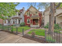 Charming two-story home boasts a well-manicured front yard and inviting curb appeal with black iron fence at 1356 N Marion St, Denver, CO 80218