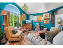 Inviting living room with comfortable seating, colorful decor, and large window with natural light at 8653 E Dry Creek Rd # 1121, Englewood, CO 80112