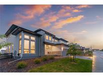 Inviting two-story home showcasing large windows and a stone accent wall at 303 Rogers Ct, Castle Rock, CO 80104
