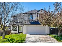 Charming two-story home featuring a white brick facade, well-maintained lawn, and an attached two-car garage at 19721 E Vassar Ave, Aurora, CO 80013