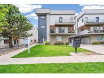 Modern three-story townhome with attached garage and landscaped lawn at 1615 Julian St # 102, Denver, CO 80204