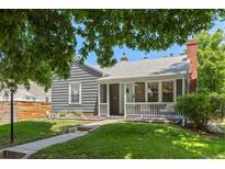 Charming home with grey siding, brick chimney, covered porch, and green lawn at 1738 S Franklin St, Denver, CO 80210