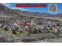 Expansive aerial view of a neighborhood nestled against the mountains, highlighting the community's natural setting at 580 Eagle Nest Ct, Golden, CO 80401