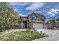 Charming two-story home with stone accents, a three-car garage, and a beautifully landscaped front yard at 580 Eagle Nest Ct, Golden, CO 80401