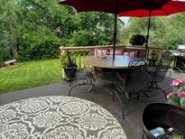 Inviting back deck features comfortable seating, a dining table, and a well-maintained lawn at 18655 E Garden Pl, Aurora, CO 80015