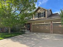 Two-story home featuring a two-car garage, covered porch and well-maintained lawn at 18655 E Garden Pl, Aurora, CO 80015