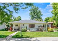 Charming home with a well-manicured lawn, sidewalk and beautiful landscaping in front at 3177 S Grant St, Englewood, CO 80113