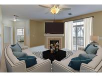 Bright living room boasts neutral walls, a fireplace, a ceiling fan, and access to a balcony at 3281 E 103Rd Pl # 1403, Thornton, CO 80229