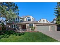 Charming two-story home featuring a brick and siding exterior, a well-manicured lawn, and an attached three-car garage at 5775 S Pagosa Way, Centennial, CO 80015