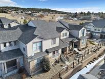 A multi-level home with stone accents, complemented by a landscaped yard and a view of rolling hills at 726 Vista Verde Hts, Monument, CO 80132