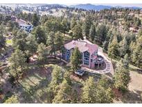 Stunning aerial view of a home with lush greenery and a circular driveway at 24140 Us Highway 40, Golden, CO 80401