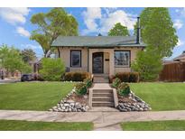 Charming home featuring a well-manicured lawn, inviting front steps, and lovely landscaping at 1804 S Corona St, Denver, CO 80210