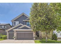 Charming two-story home with a well-manicured lawn, brick accents and a covered porch entryway at 10330 Lions Path, Lone Tree, CO 80124