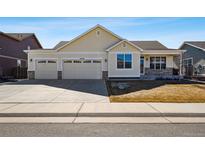 Charming single-Gathering home features a three-car garage and manicured front yard on a sunny day at 56582 E 23Rd Ave, Strasburg, CO 80136