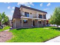 A two-story home with a balcony and well-maintained lawn, showcasing traditional architectural details at 11402 W 17Th Pl, Lakewood, CO 80215