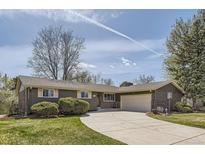 Charming single-story home features a well-manicured lawn, a circular driveway, and a two-car garage at 5876 W Canyon Ave, Littleton, CO 80128