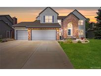 Charming two-story home with brick and siding, three-car garage, manicured lawn, and front patio at 10 Sand Cherry, Littleton, CO 80127