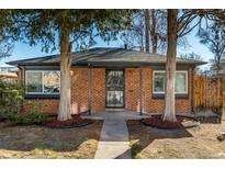 Charming red brick home with mature trees and a well-manicured lawn at 832 Dahlia St, Denver, CO 80220