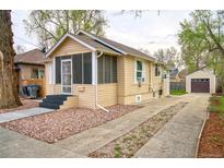 Charming bungalow with a screened-in porch and long driveway leading to detached garage at 504 Martin St, Longmont, CO 80501
