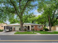 Charming single-story brick home with a well-manicured lawn and mature trees at 9656 Rensselaer Dr, Arvada, CO 80004