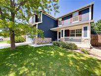 Charming two-story home with blue siding, red shutters, a stone foundation and a well-manicured lawn at 4049 S Quatar St, Aurora, CO 80018