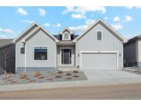 Gray modern farmhouse exterior with two-car garage and landscaping at 616 Scrubjay Cir, Castle Rock, CO 80104